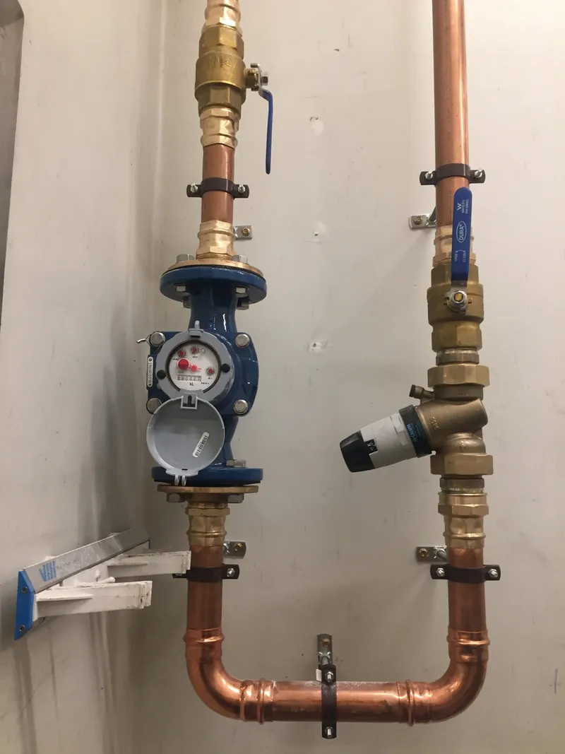 A brass and copper water meter with a testable backflow prevention assembly