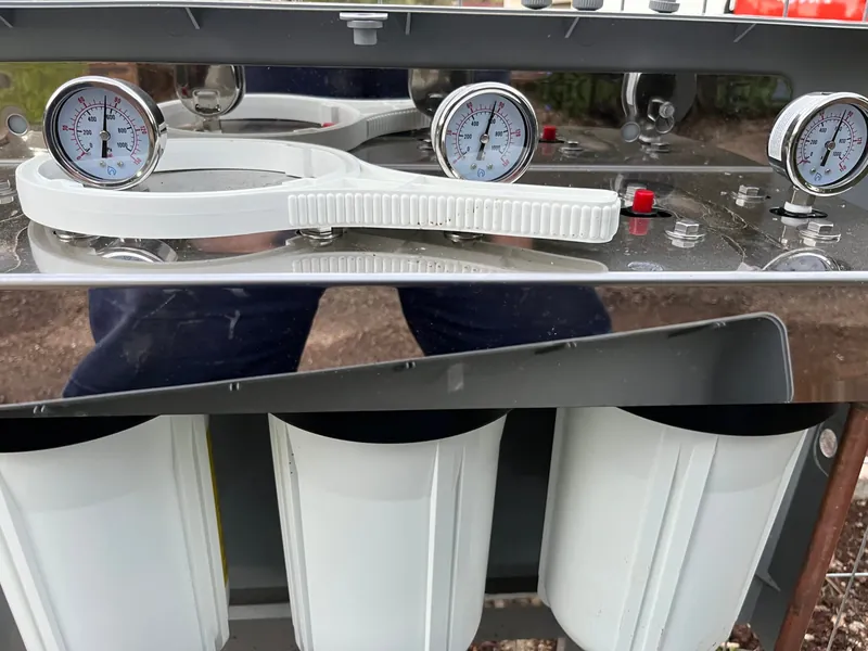 A three stage water filtration system with pressure gauges fitted above each filter housing